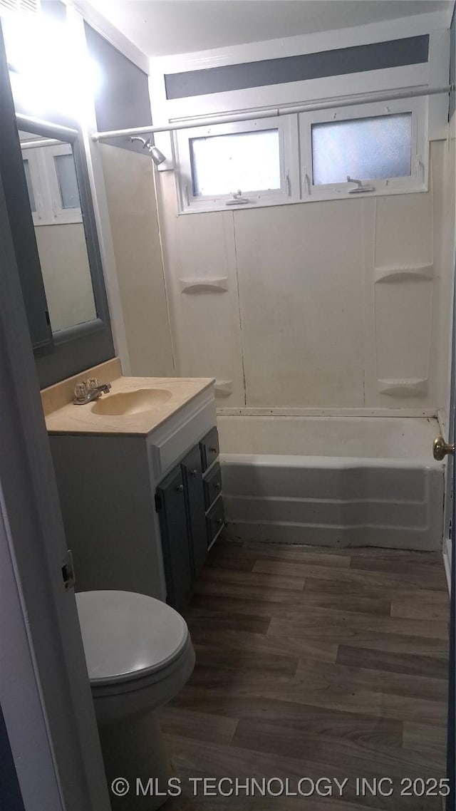 full bath featuring toilet, shower / bathtub combination, wood finished floors, and vanity