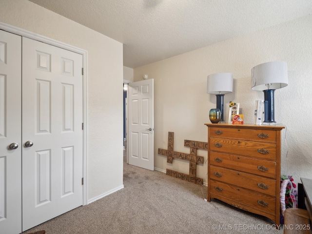 bedroom featuring a textured ceiling, carpet floors, and baseboards