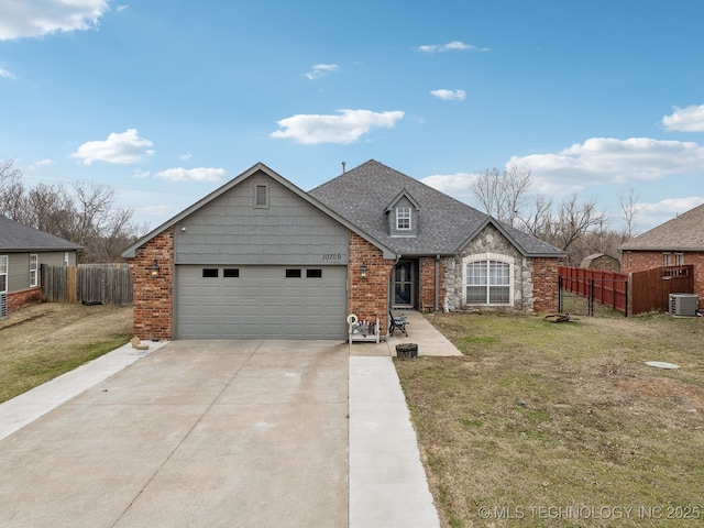 traditional-style home featuring concrete driveway, central AC, fence, and brick siding