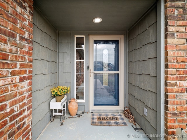 view of exterior entry with brick siding