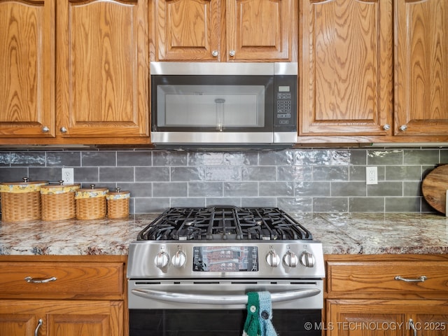 kitchen with brown cabinetry, stainless steel appliances, and backsplash