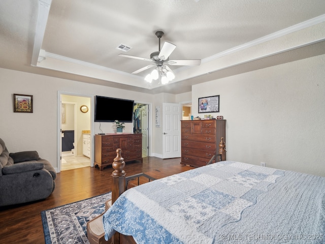 bedroom with a raised ceiling, visible vents, crown molding, and wood finished floors