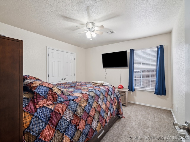 carpeted bedroom with baseboards, visible vents, a textured ceiling, and a textured wall