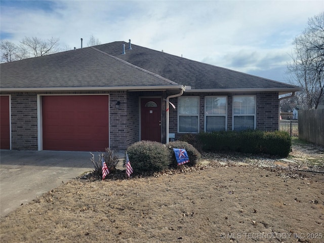 ranch-style house featuring roof with shingles, brick siding, concrete driveway, an attached garage, and fence