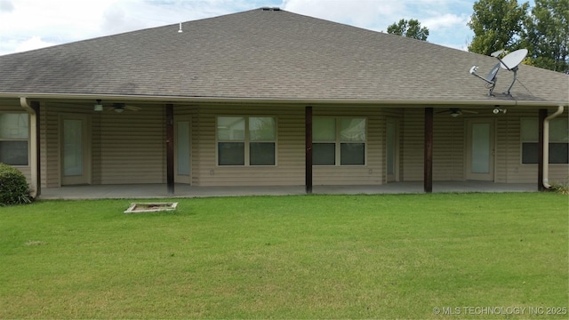 rear view of house with a patio, a yard, roof with shingles, and a ceiling fan