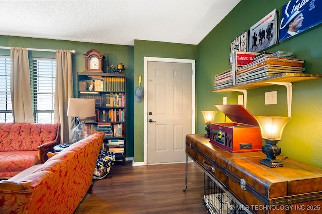 interior space featuring a textured ceiling, baseboards, and wood finished floors