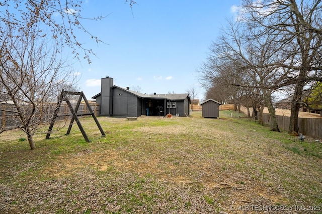 view of yard with a storage shed, an outdoor structure, and fence