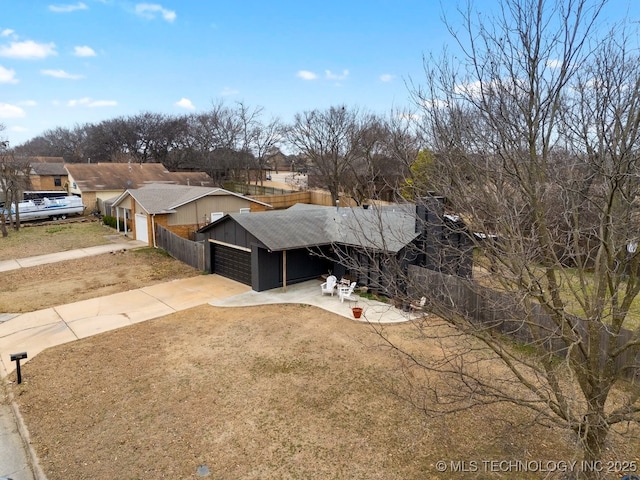 view of front of property with a garage, driveway, and fence