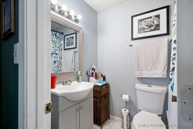 bathroom featuring tile patterned flooring, toilet, vanity, baseboards, and a shower with curtain