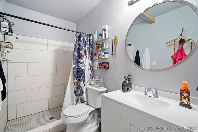 bathroom featuring a textured wall, tiled shower, vanity, and toilet