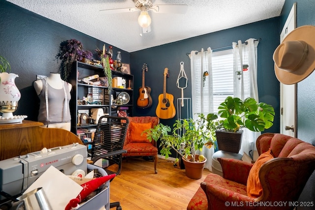 interior space featuring a textured ceiling, wood finished floors, and a ceiling fan