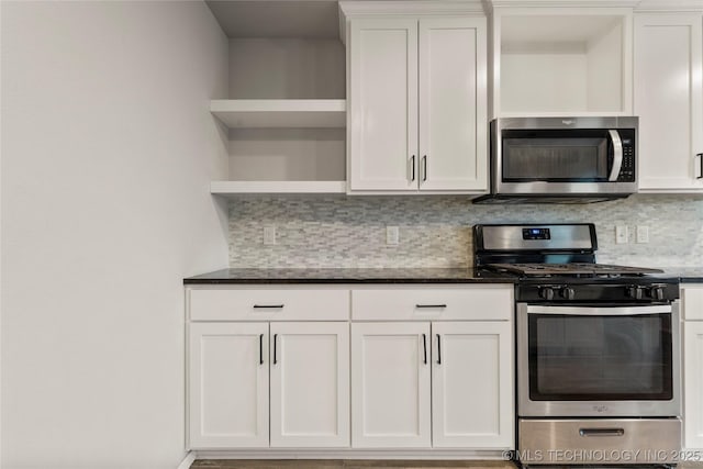 kitchen featuring dark stone counters, stainless steel appliances, white cabinetry, open shelves, and backsplash