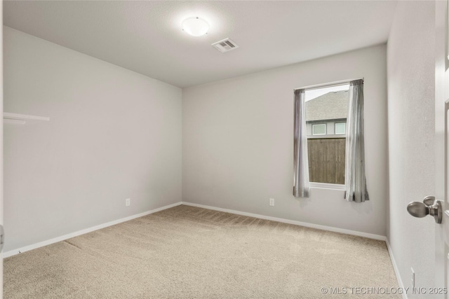 carpeted empty room with visible vents and baseboards