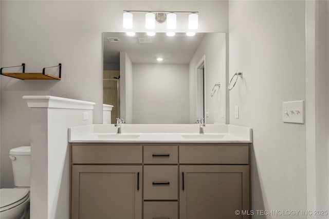 bathroom with visible vents, a sink, toilet, and double vanity