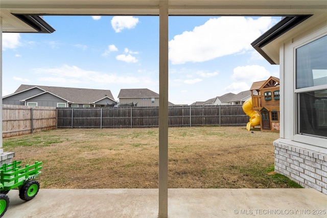 view of yard featuring a playground, a fenced backyard, and a residential view