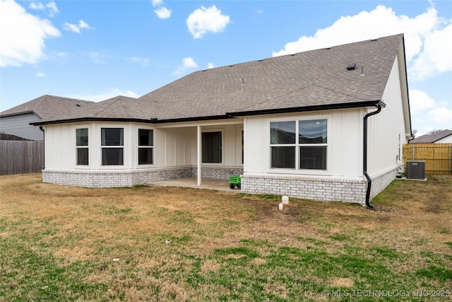 back of house featuring a yard, central AC, fence, and a shingled roof