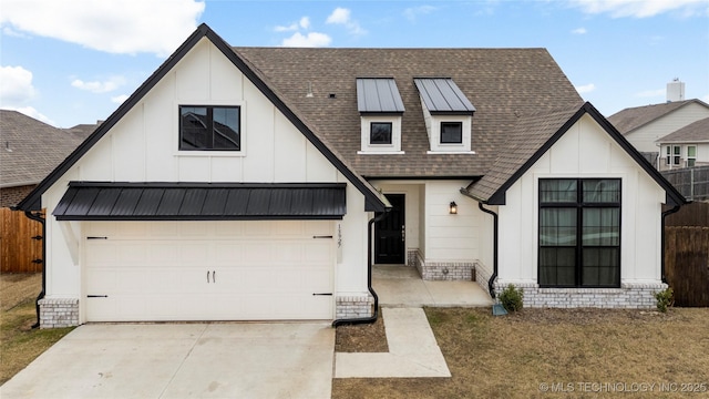 modern farmhouse style home featuring a standing seam roof, metal roof, concrete driveway, and roof with shingles