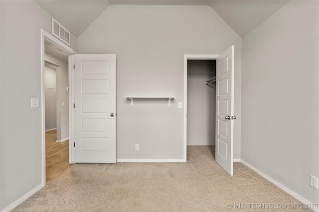 unfurnished bedroom featuring visible vents, vaulted ceiling, and carpet flooring