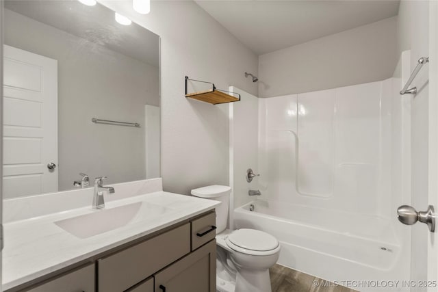 full bath with washtub / shower combination, vanity, toilet, and wood finished floors