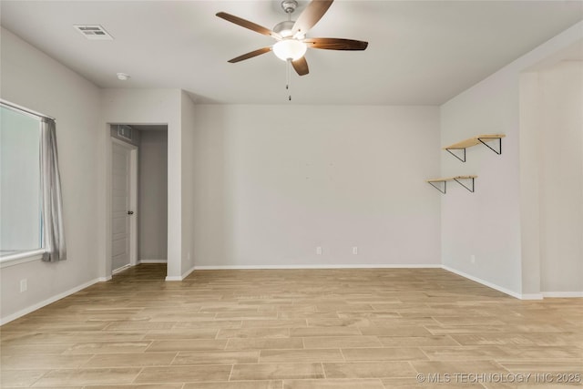 empty room with light wood finished floors, baseboards, and visible vents