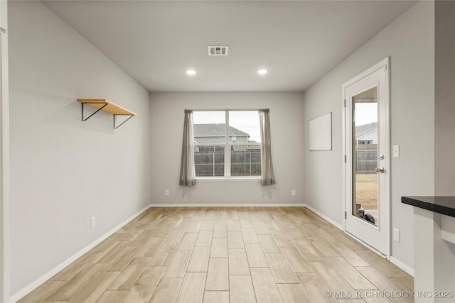 unfurnished room with light wood finished floors, recessed lighting, visible vents, and baseboards