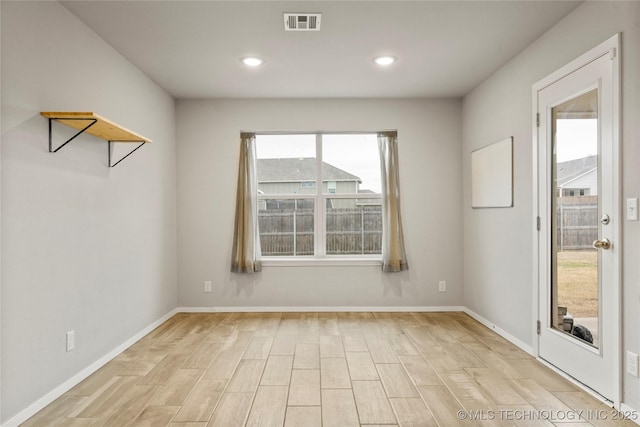 unfurnished room featuring light wood finished floors, recessed lighting, visible vents, and baseboards