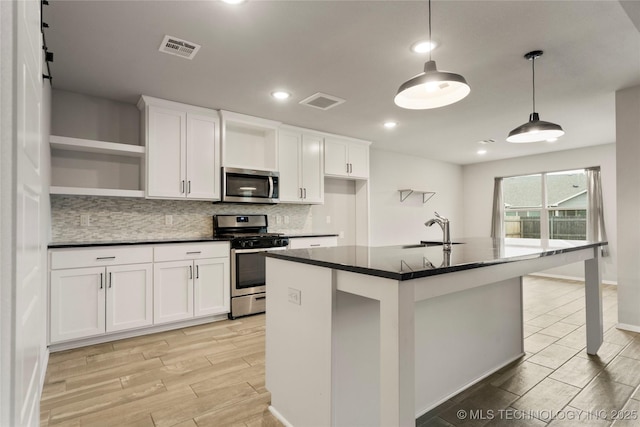 kitchen with stainless steel appliances, a sink, visible vents, open shelves, and dark countertops