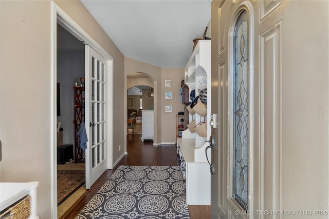 entrance foyer with baseboards and arched walkways