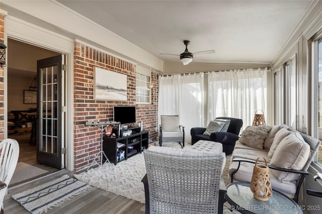 living area featuring ornamental molding, wood finished floors, and a ceiling fan