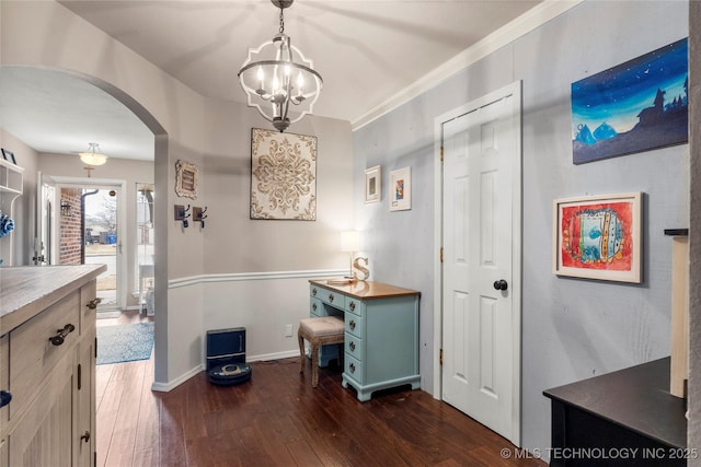 interior space with baseboards, arched walkways, and dark wood finished floors