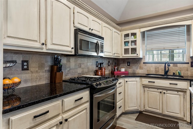 kitchen featuring tasteful backsplash, vaulted ceiling, stainless steel appliances, and a sink