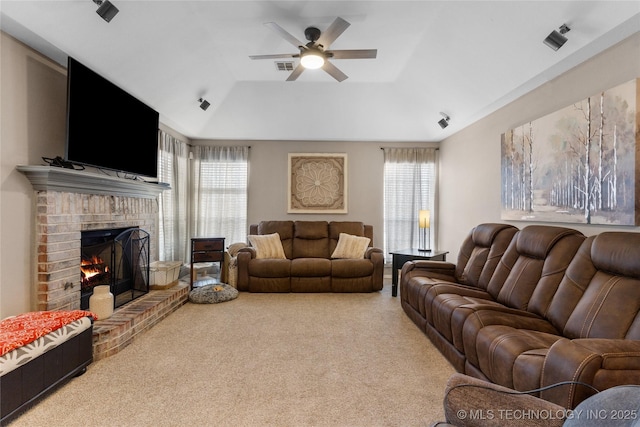 living room with visible vents, a raised ceiling, ceiling fan, carpet floors, and a fireplace