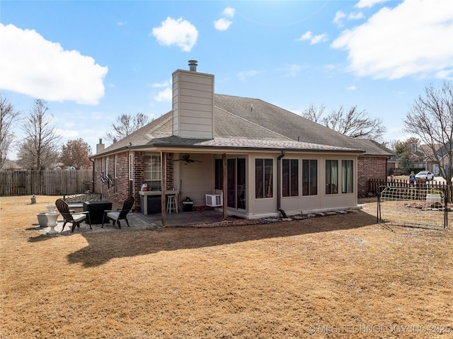 rear view of house featuring a ceiling fan, a patio, a fenced backyard, a chimney, and brick siding