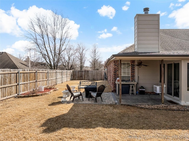 view of yard with ceiling fan, a patio, a fire pit, and a fenced backyard