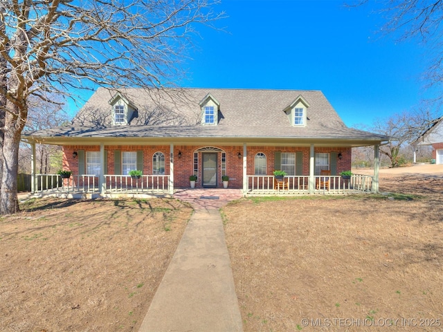 view of front facade featuring a front lawn, a porch, and brick siding