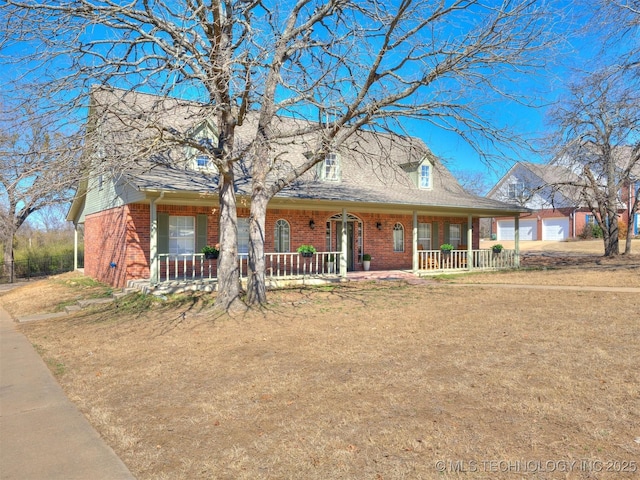 view of front of property with a porch, an attached garage, and brick siding