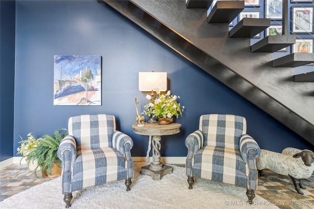 living area with vaulted ceiling, carpet flooring, and baseboards