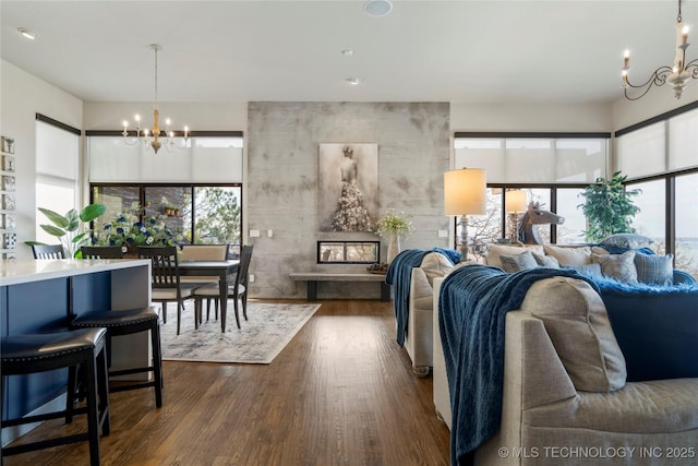 living room with dark wood-style flooring and an inviting chandelier