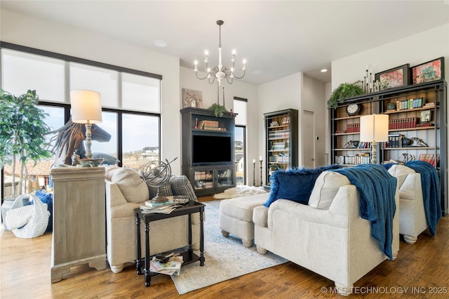 living room featuring a chandelier, recessed lighting, and wood finished floors