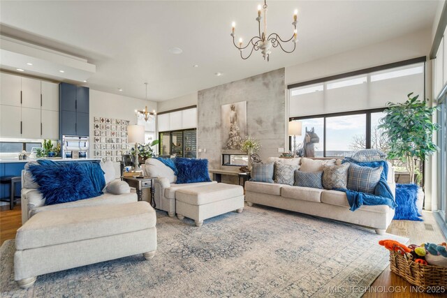 living area with recessed lighting, wood finished floors, and a notable chandelier