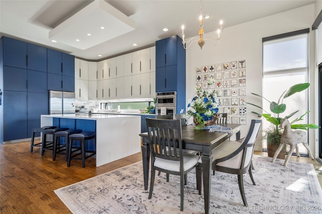 dining space featuring a high ceiling, an inviting chandelier, recessed lighting, and light wood-style floors