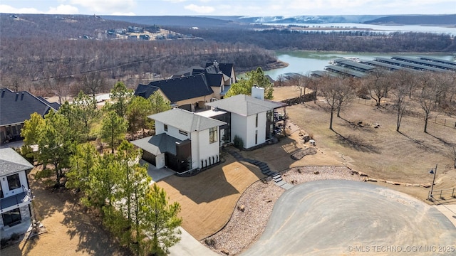 bird's eye view with a water view and a wooded view