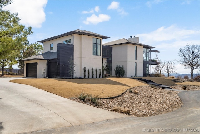 view of property exterior with a garage, driveway, and a balcony