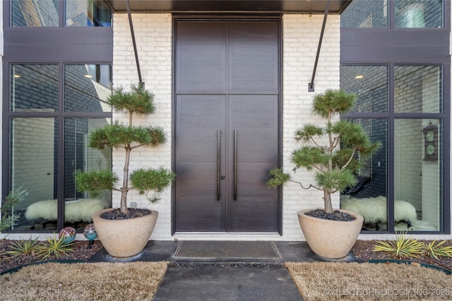 entrance to property featuring brick siding