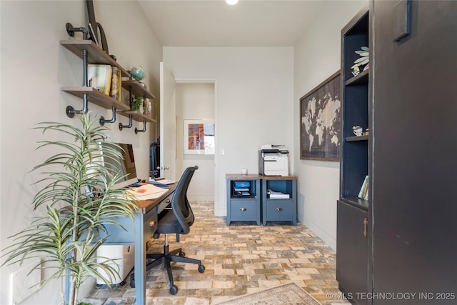 office area featuring brick floor and baseboards