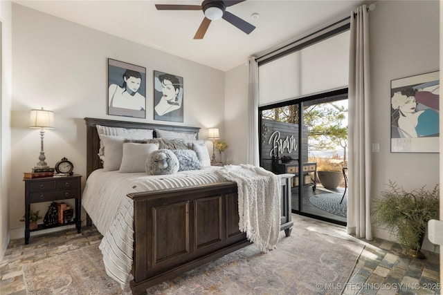 bedroom featuring access to exterior, stone finish flooring, and a ceiling fan