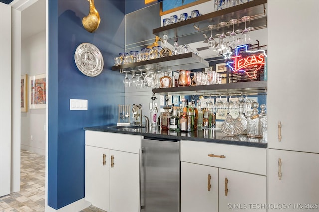 bar with wet bar, stainless steel fridge, and a sink