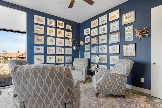 sitting room featuring baseboards and a ceiling fan