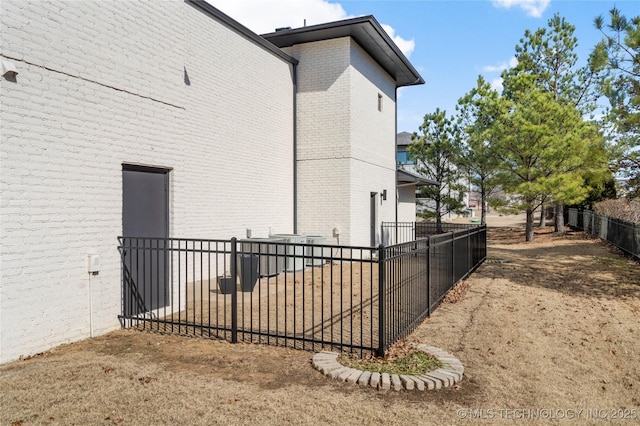 view of side of property featuring brick siding and fence