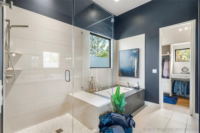 full bath featuring a garden tub, a shower stall, baseboards, and tile patterned flooring